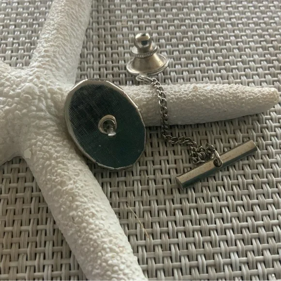 Vintage scrimshaw tie tac with a tall sailing ship.